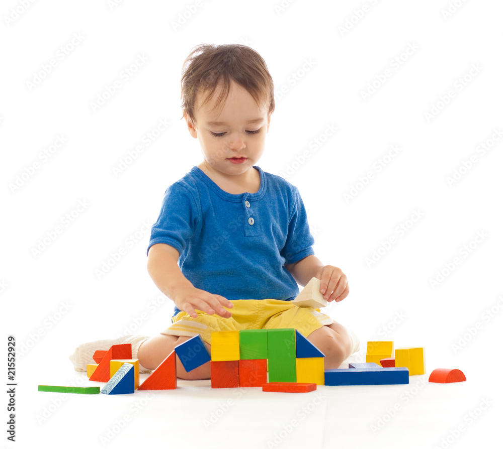 Cute little boy is playing with colorful building wooden blocks Cute little boy is playing with colorful building wooden blocks