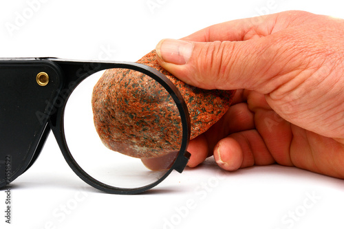 A black magnifying glass and stone photo