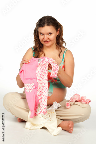 Pregnant woman holding baby bodysuit