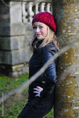 Outdoor Portrait Of Young Woman Leaning Against A Tree