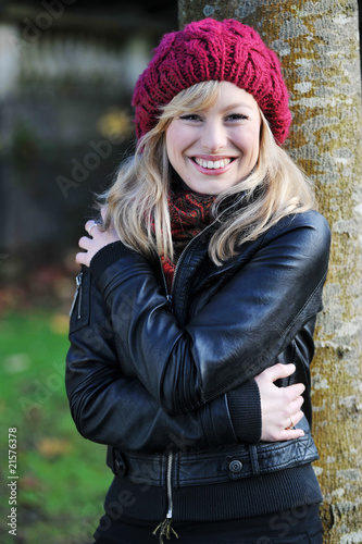 Happy Young Woman Leaning Against A Tree