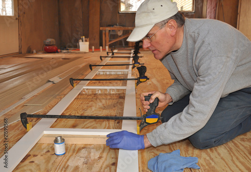 Carpenter adjusting clamp on exterior trim assembly