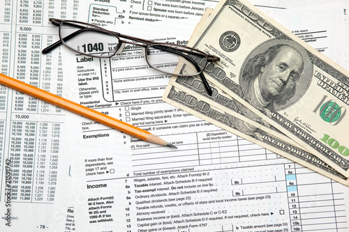 Tax time - Closeup of U.S. 1040 tax return with pencil and glass