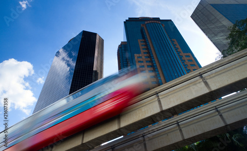 Modern monorail train with office buildings in the background