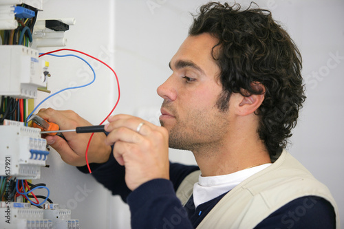 Portrait d'un électricien travaillant sur un compteur électrique