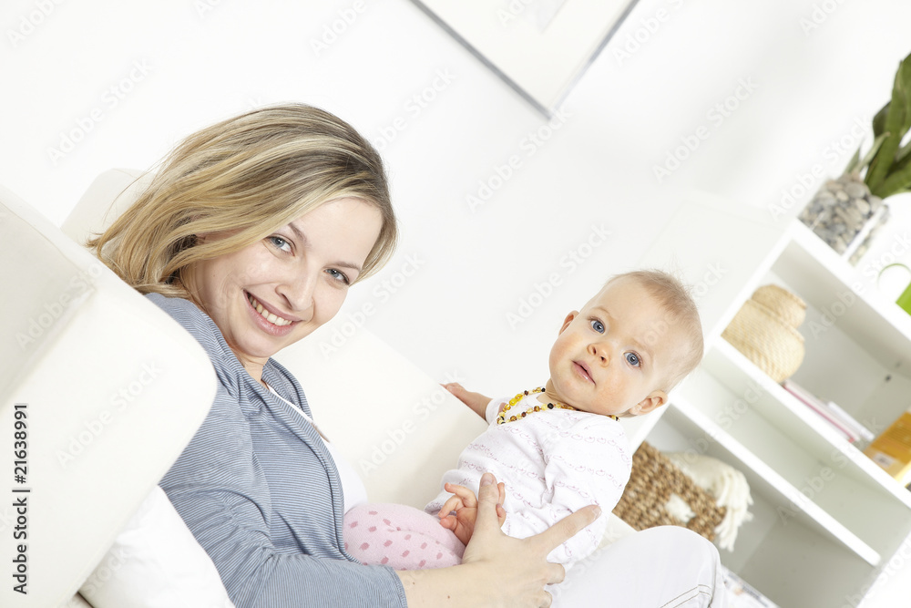 junge mutter mit baby auf weißem sofa