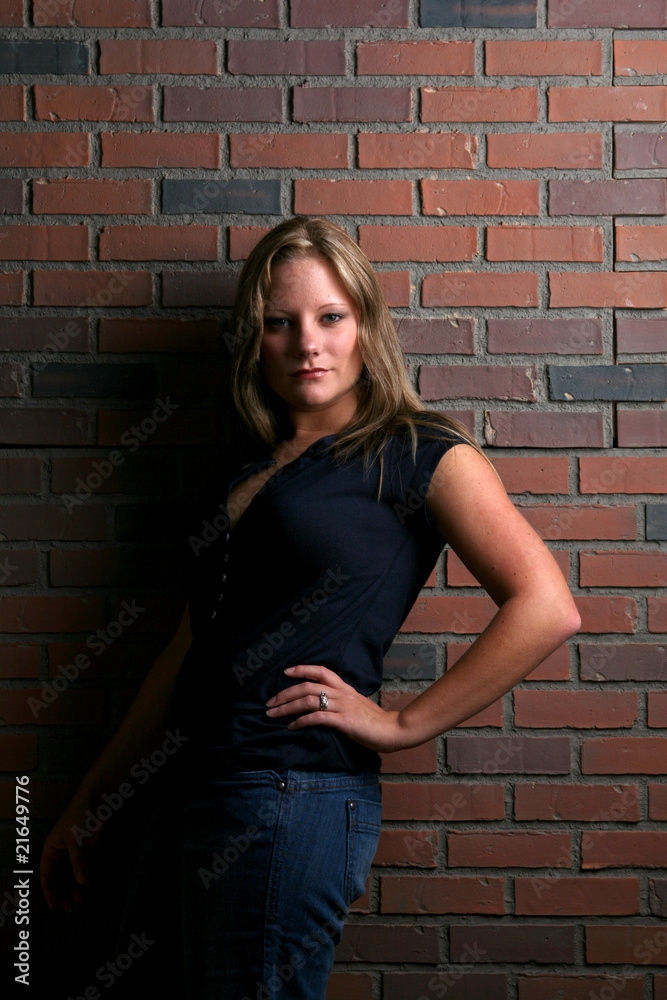 pretty woman in black shirt against brick wall pretty woman in black shirt against brick wall