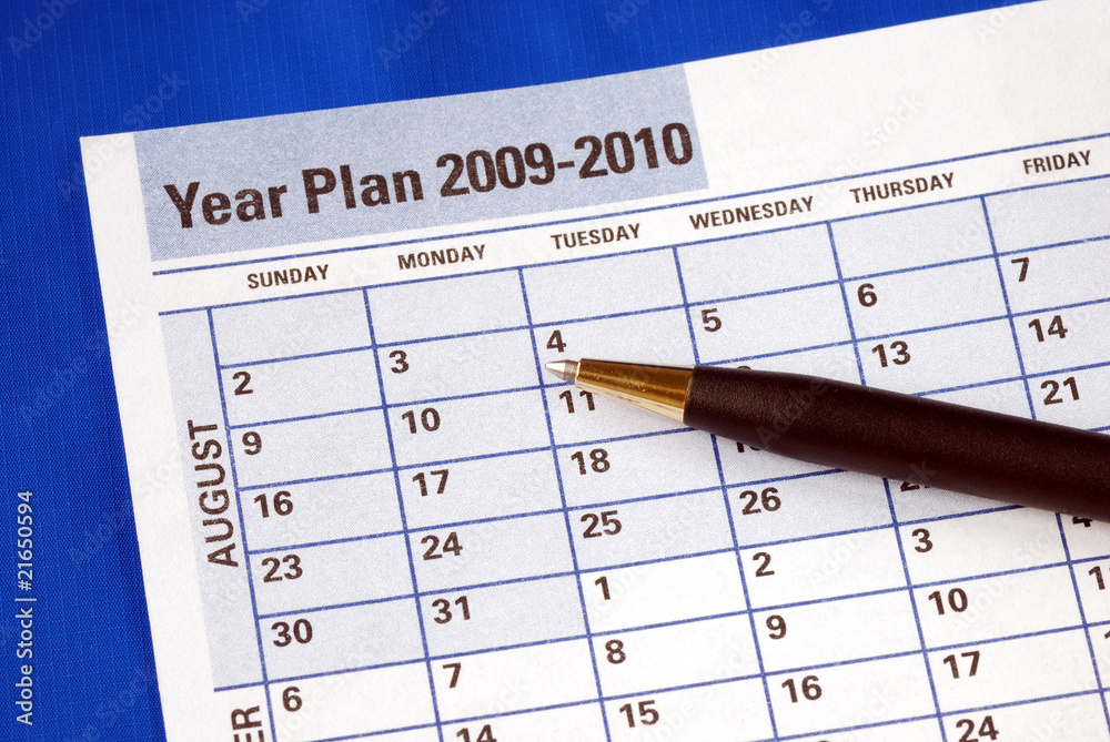Planning the year on the day planner isolated on blue Planning the year on the day planner isolated on blue