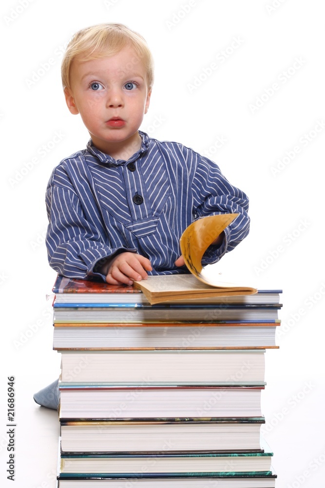 Kleiner lesender Junge hinter Bücherstapel Kleiner lesender Junge hinter Bücherstapel