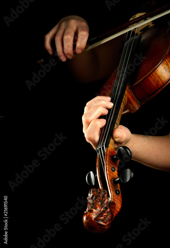 Musician playing violin isolated on black.