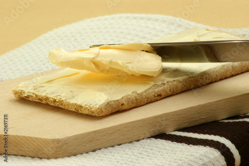 Knäckebrot wird mit Butter bestrichen