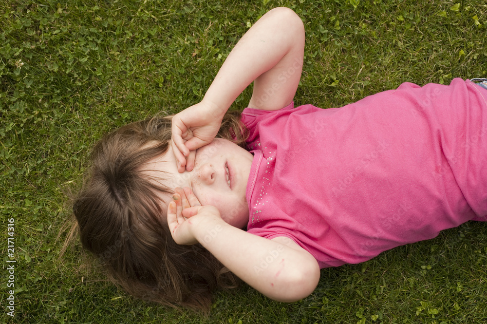 little girl laying in grass