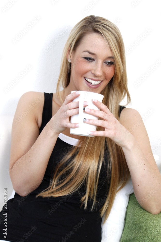 Lachend auf dem Sofa mit Kaffee Lachend auf dem Sofa mit Kaffee