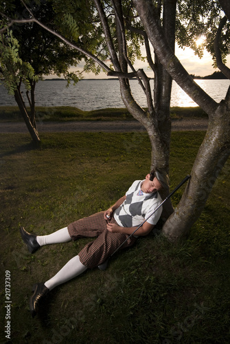 Tired golfer taking a nap.