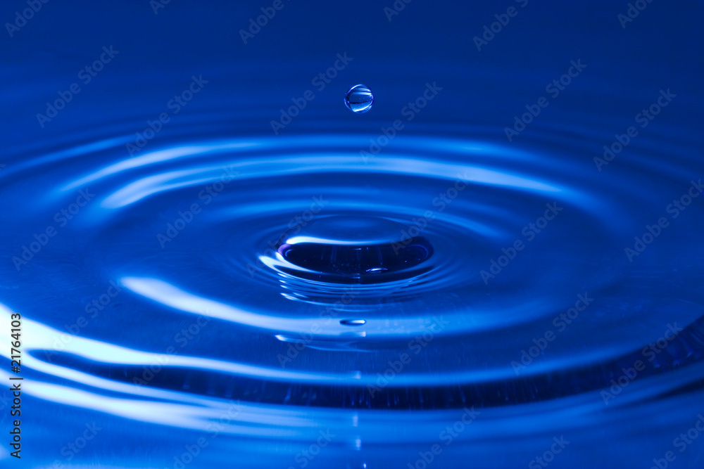 close-up of a droplet, falling in the blue water close-up of a droplet, falling in the blue water