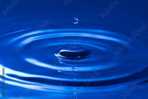 close-up of a droplet, falling in the blue water
