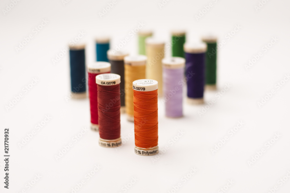 Colored thread bobbin, mins and meter on white background Colored thread bobbin, mins and meter on white background