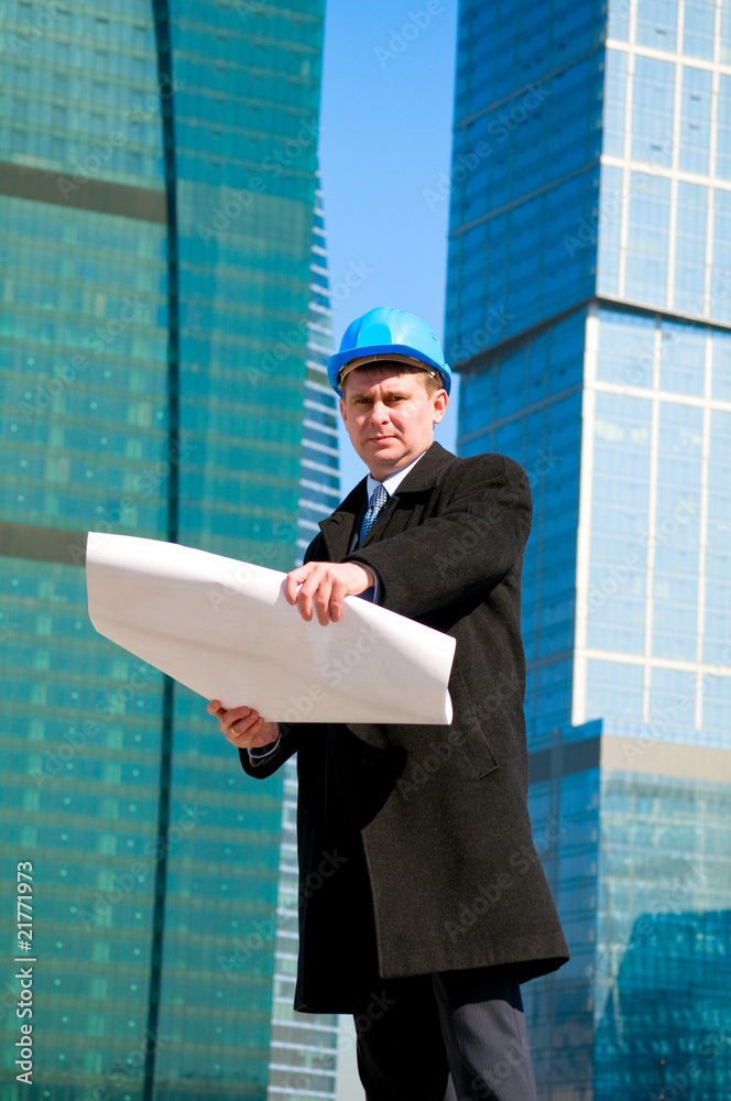 Engineer with blue hard hat holding drawing