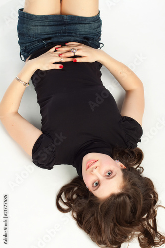 A pretty young woman lying on the floor.