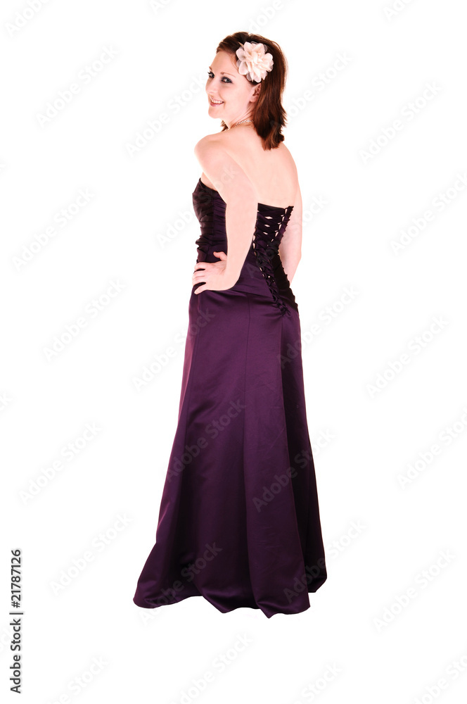 Young pretty girl standing in burgundy evening dress.