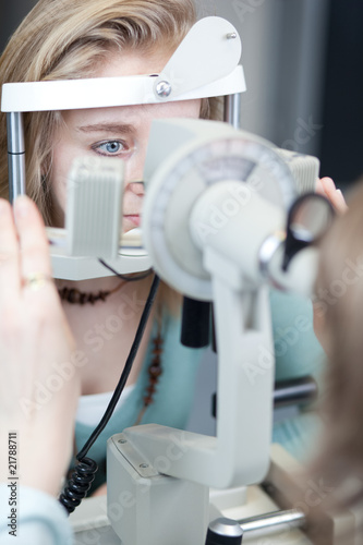 optometry concept - pretty young woman having her eyes examined