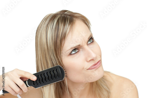 Annoyed woman bruishing her hair