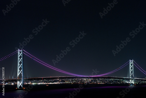 橋脚の間で青く輝く明石海峡大橋のイルミネーション
