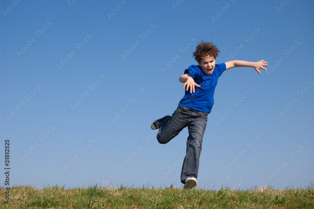Boy jumping, running against blue sky Boy jumping, running against blue sky