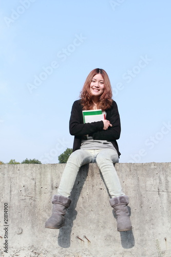 young asian girl reading outdoor
