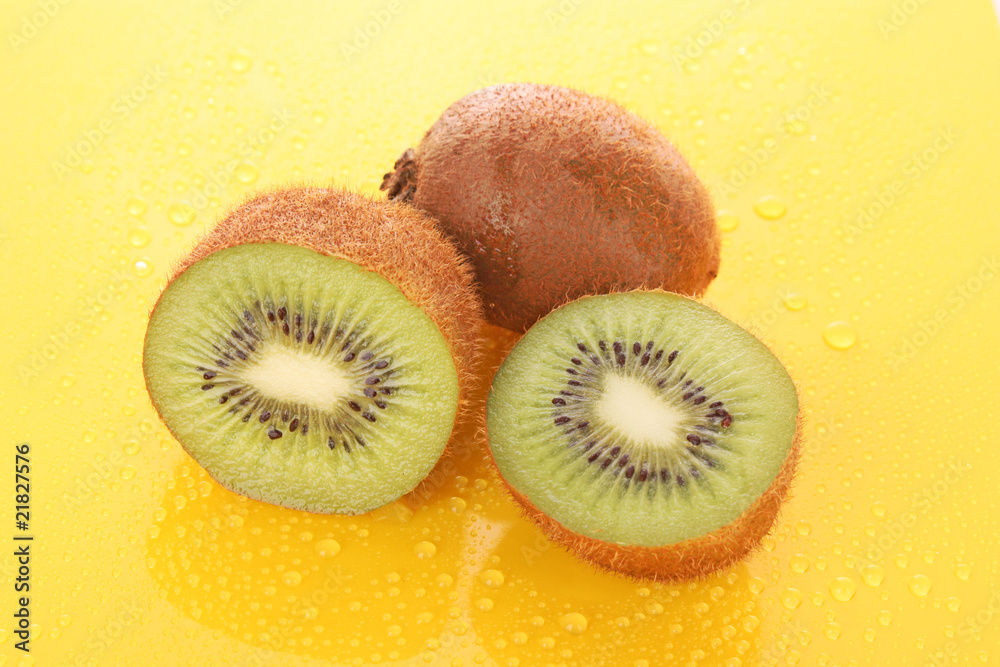 Obraz premium Wet kiwi on yellow background