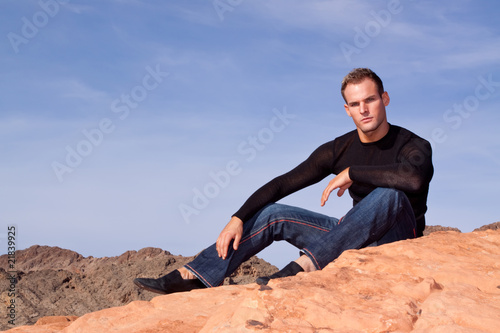 Stylish young man resting on the rocks