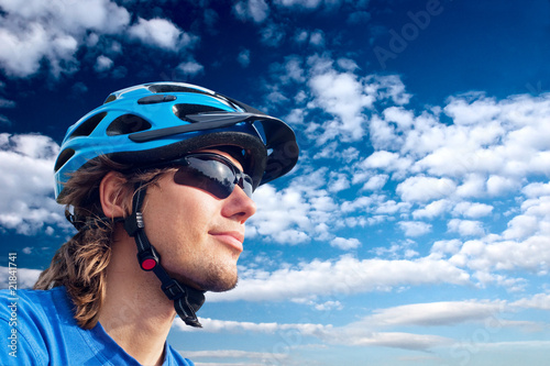 portrait of a young bicyclist in helmet and glasses