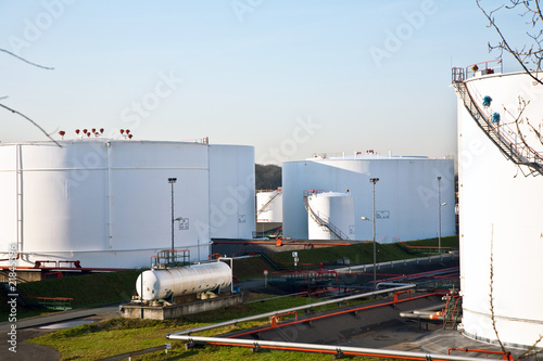 white tanks in tank farm with blue sky photo