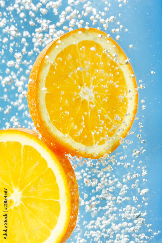 Fresh orange dropped into water with bubbles. Fresh orange dropped into water with bubbles.