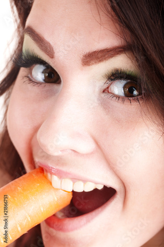 Face of girl eating carrot. Isolated.
