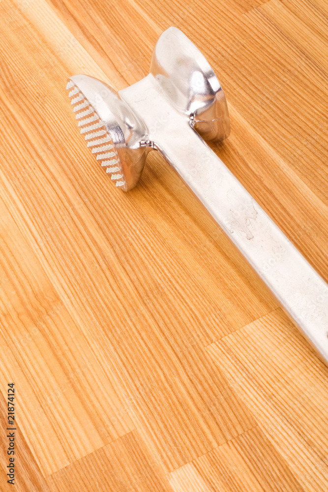 aluminium meat tenderizer isolated on wooden background.