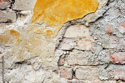 Fragment of tumbledown plastered brick wall