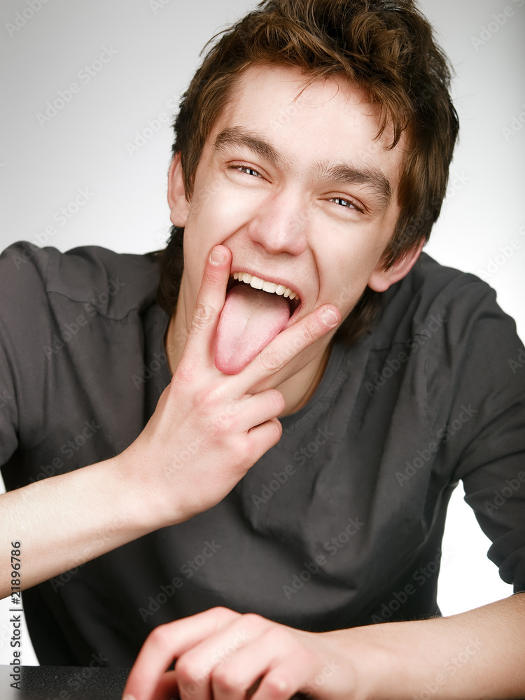Smiling fun man with victory gesture and put one's tongue out Smiling fun man with victory gesture and put one's tongue out