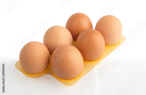 Fresh brown eggs in plastic carton