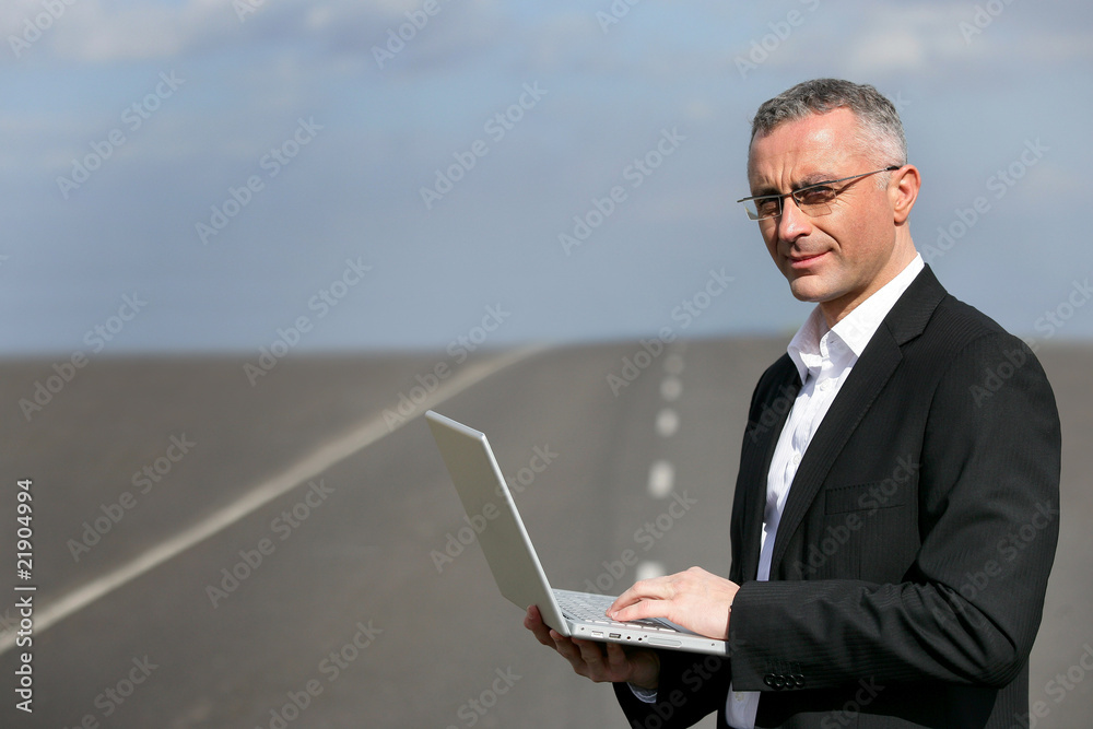 Homme d'affaires debout, devant un ordinateur portable Homme d'affaires debout, devant un ordinateur portable