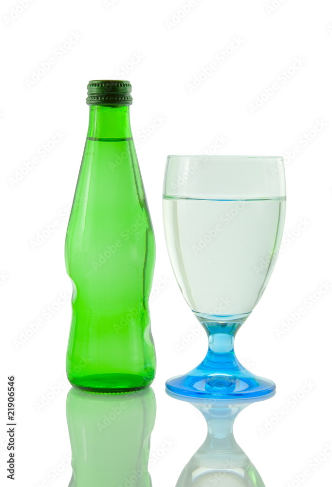 Bottle and glass of mineral water reflected on white background