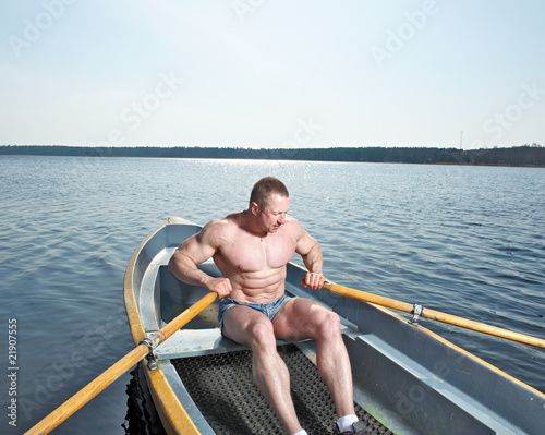 Muscular man with oars in boat © Al Troin