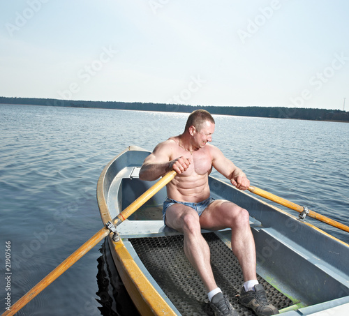 Muscular man with oars in boat © Al Troin