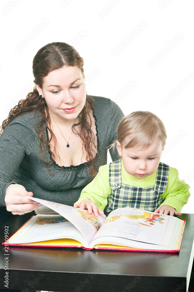 Little child and mother together read the book at a table Little child and mother together read the book at a table