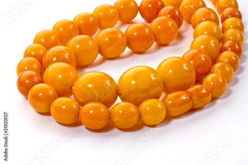 Amber chaplet lying on a white surface
