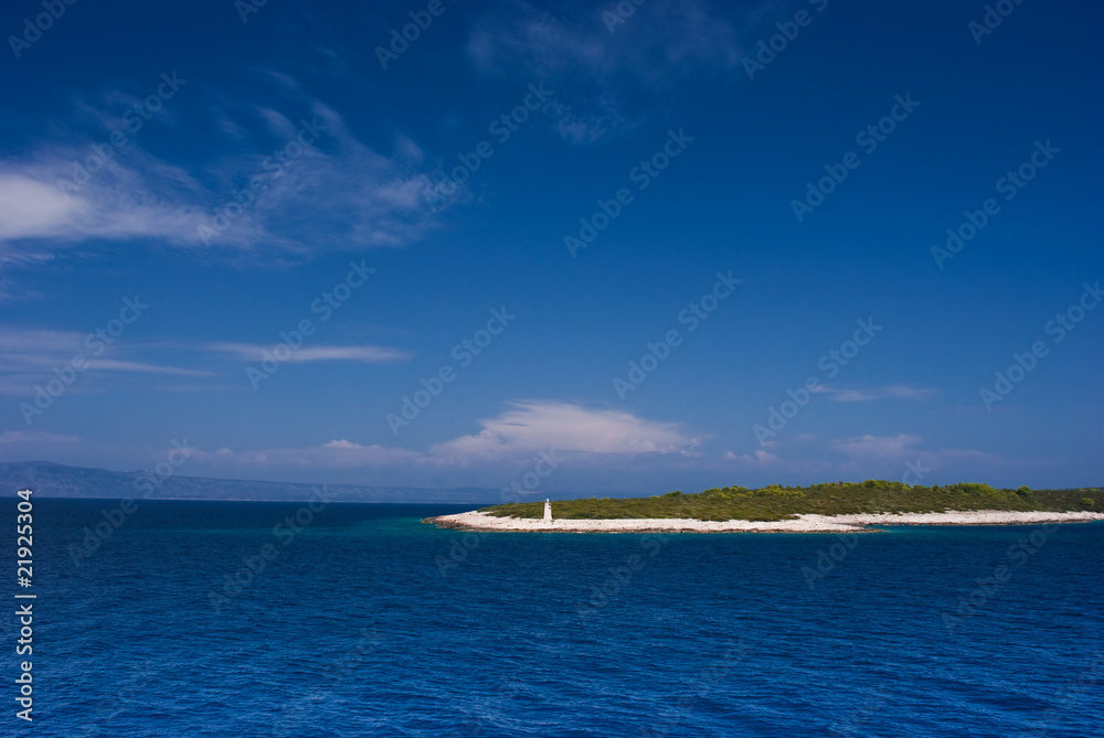 Croatian island in Adriatic blue sea with lighthouse.