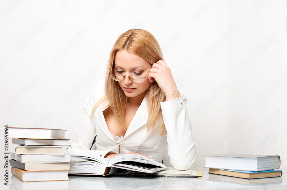 Young pretty woman learning at table with books Young pretty woman learning at table with books