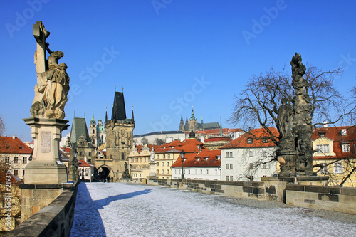 The snowy Prague's gothic Castle with the Charles Bridge