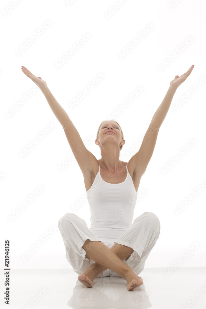 young woman dressed in white sitting cross-legged doing yoga young woman dressed in white sitting cross-legged doing yoga