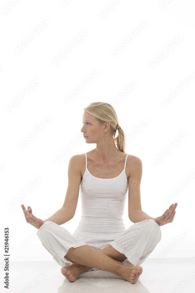 young woman dressed in white sitting cross-legged doing yoga young woman dressed in white sitting cross-legged doing yoga